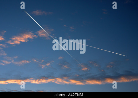 Zwei Flugzeuge Contrailing vor einem Sonnenuntergang Himmel, Todwick, South Yorkshire, England Stockfoto