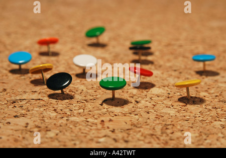 bunte Reißnägel auf einer Pinnwand Stockfoto