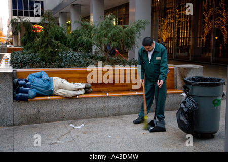 Streetcleaner arbeiten rund um Obdachloser auf Bank schlafen Stockfoto
