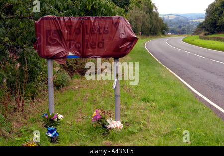 Blumen mit einzelnen Handschuh links am Tatort eines tödlichen Unfalls auf der A40 zwischen Bwlch und Brecon Powys South Wales UK Stockfoto