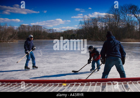 Jungs spielen Eishockey auf einem zugefrorenen Teich Stockfoto