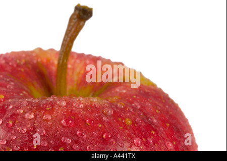 Roter Apfel mit Wassertropfen auf isoliert auf weißen geringe Schärfentiefe gerahmt in der linken Ecke, um Raum für Kopie erlauben Stockfoto