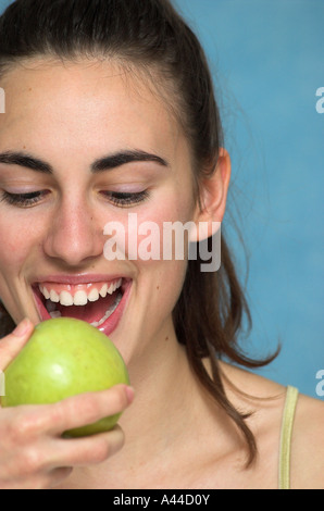 Lächelnde junge Frau hält Apfel Stockfoto