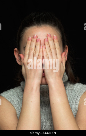 Junge Frau Deckung Gesicht mit Händen hautnah Stockfoto