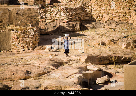 Frau für Wasser im Dorf Sanga in der Dogon-Land, Mali, Westafrika Stockfoto