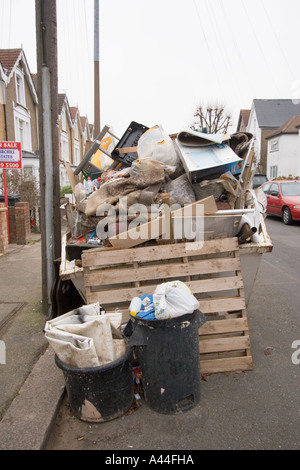 Nicht lizenziert und überlastet Skip in der Straße voller DIY Müll außerhalb Haus zu verkaufen oder verkauft Haus in Chingford North East London Stockfoto