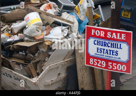 Nicht lizenziert und überlastet Skip in der Straße voller DIY Müll außerhalb Haus zu verkaufen oder verkauft Haus in Chingford North East London Stockfoto