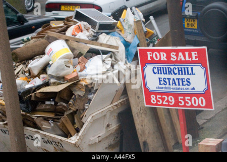 Nicht lizenziert und überlastet Skip in der Straße voller DIY Müll außerhalb Haus zu verkaufen oder verkauft Haus in Chingford North East London Stockfoto