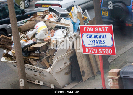 Nicht lizenziert und überlastet Skip in Straße, voll von DIY Müll außerhalb privaten Wohn-Gehäuse Chingford North East London UK Stockfoto