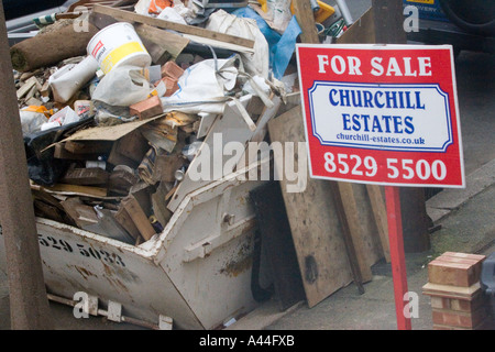 Nicht lizenziert und überlastet Skip in der Straße voller DIY Müll außerhalb Haus zu verkaufen oder verkauft Haus in Chingford North East London Stockfoto