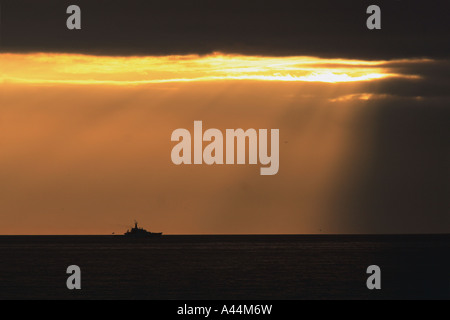 Royal Navy Schiff am Horizont bei Sonnenuntergang Stockfoto