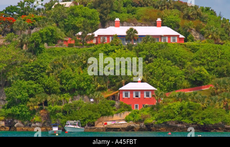 Häuser in Pembroke Parish mit Blick auf die Bucht A Bootshaus imitiert das Design und die Farbe der höheren Villa am Hang Stockfoto