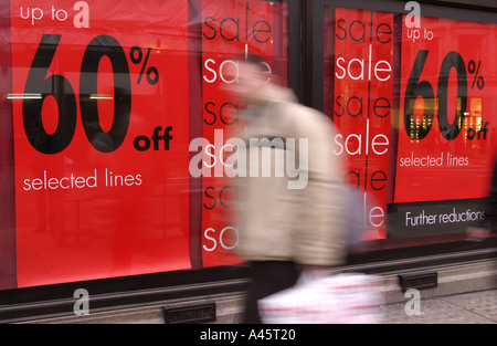 eine Shopper geht vorbei an Zeichen ankündigen, Vertrieb und Rabatte in Oxford street Stockfoto