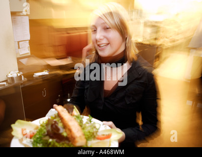 Kellnerin serviert die Mahlzeit Stockfoto