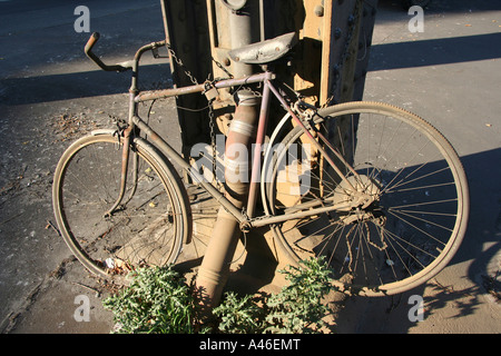 Zerstörte Fahrrad an eine Säule gefesselt Stockfoto