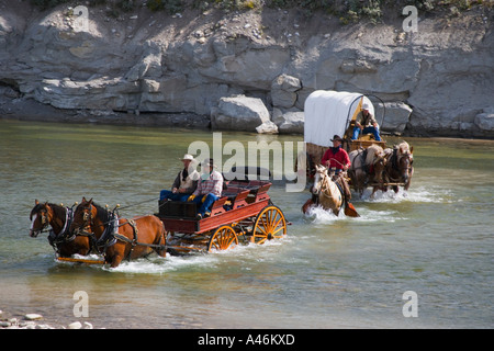 Cowboys und einem Planwagen Überquerung eines Flusses Stockfoto