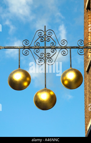 Pfandhaus Nahaufnahme von traditionellen Zeichen der drei goldenen Kugeln über Pfandleiher Geschäftslokale auf ornamentalen Eisen Halterung England UK unterstützt Stockfoto