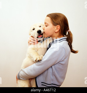 Mädchen küssen Labrador-Welpe Stockfoto