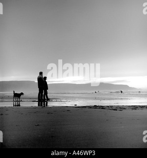 Romantisch zu zweit mit ihrem Hund am Strand Cornwall Bude Stockfoto