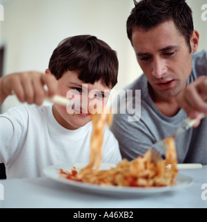 Vater und Sohn Spaghetti-Essen Stockfoto