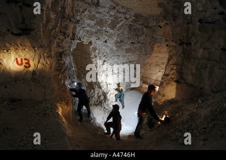 Vier unerschrockene Höhlenforscher mapping ein Labyrinth aus alten weissen Mine Tunnel 70ft unter der Erde. Stockfoto