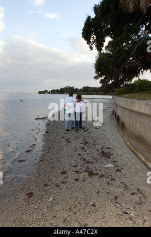 Paare, die Hand in Hand am Strand Stockfoto