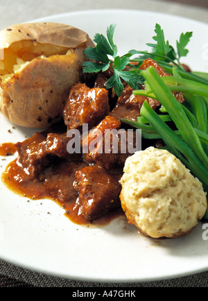 Ein Teller mit Rindfleisch Eintopf Knödel und eine Jacke Kartoffel redaktionelle Essen Stockfoto