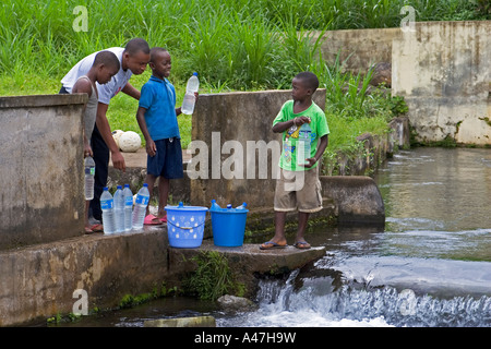 Lokalen jungen füllen Wasser in Flaschen zum trinken, Luba Stadt, Süden westlich von Insel Bioko, Äquatorial-Guinea, Zentralafrika Stockfoto