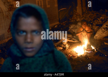 Obdachlose jungen benutzen ein Feuer, um sie warm zu halten auf der Straße von Neu-Delhi in Indien Stockfoto