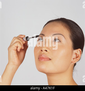 Junge Frau, die Wimperntusche auftragen Stockfoto