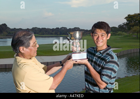 Vater und Sohn halten Trophäe Stockfoto