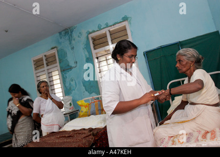 Eine indische Krankenschwester besucht ein Patient in einer ländlichen Gesundheitsversorgung Klinik in Kerala in Indien Stockfoto