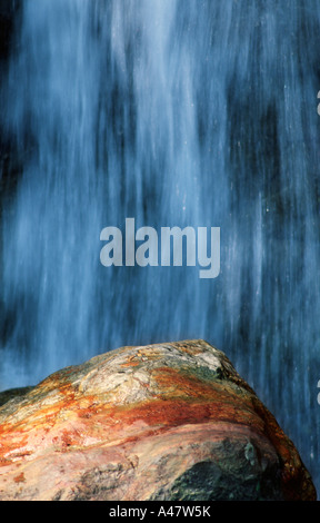 Ein Wasserfall und eine orange Boulder in den Gorges De La Diosaz in der Nähe von Servoz in den französischen Alpen Stockfoto