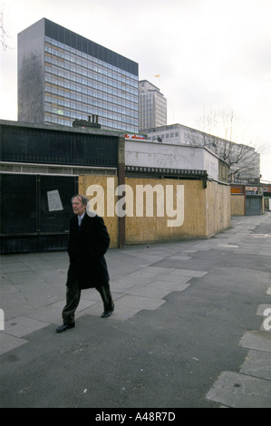 Mann in einen Mantel geht vorbei an Geschäften London Waterloo vernagelt Stockfoto