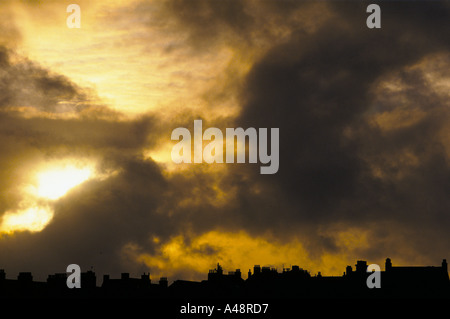Sonnenlicht durch graue und schwarze Gewitterwolken über Dach Schornsteine Lerwick Shetland Schottland Stockfoto