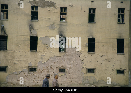 zwei Männer zu Fuß vorbei an Sarajevo Gebäude ausgebrannt Juli 1994 Stockfoto