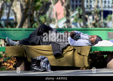 Schwarzer Obdachloser schlafen auf Parkbank Stockfoto