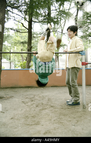 Hängen, Klettergerüst mit seinem Vater neben ihm stehenden jungen Stockfoto