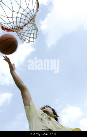 Nahaufnahme eines Basketball-Spieler schießen einen Korb Ball in einen Reifen Stockfoto