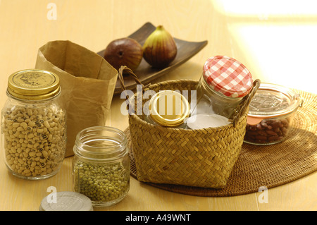 Bohnen in Gläsern mit einem Weidenkorb leere Gläser auf dem Tisch Stockfoto