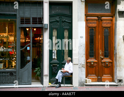 Mann liest Papier vor Geschäft in Buenos Aires, Argentinien Stockfoto