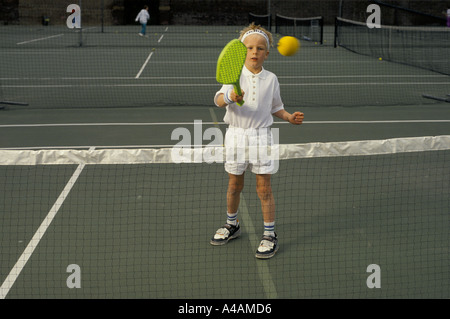 Ein Junge lernt, private coaching, London, UK ein Kunststoff-Schläger mit Tennis zu spielen. Stockfoto