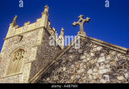 Blick von unten auf Stein Kruzifix an der Spitze der Kirche Haustreppe mit seiner Quadrat zinnengekrönten Glockenturm hinter sich und tief blauen Himmel Stockfoto