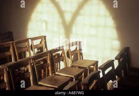 Projektion in warmes Licht an Wand des gotischen dekoriert Stilfenster mit einfachen Glas und Licht strömt auf Stuhlreihen Stockfoto