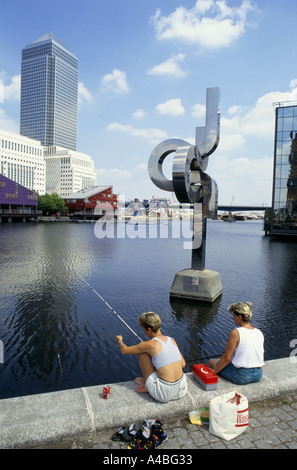 ZWEI FRAUEN ANGELN VOR CANARY WHARF TOWER, AM RIVERSIDE, LONDON DOCKLANDS. ENGLAND 1997 Stockfoto
