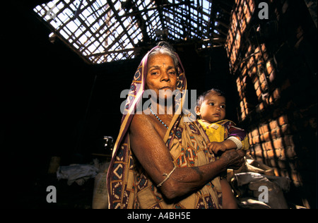 Orissa Wirbelsturm, Indien, 1999: diese Frau hält ihre Enkelin im Inneren ihres Hauses-das Strohdach durch den Zyklon zerstört Stockfoto