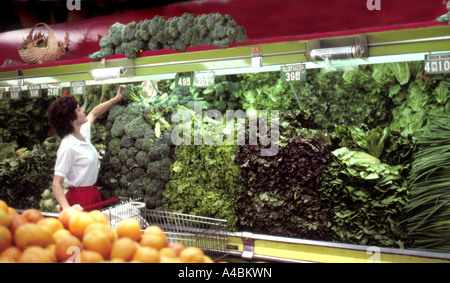 Frau einkaufen von Lebensmitteln, einschließlich Brokkoli und anderes Gemüse in der Gemüseabteilung eines Supermarktes Lebensmittelgeschäft. Stockfoto