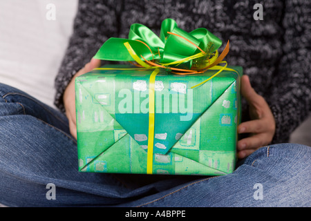 Frau auf Sofa hält Weihnachtsgeschenk Stockfoto