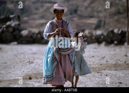 Achoma, Peru. Lächelnde Frau in traditioneller Kleidung mit bestickte Weste mit ihrer Tochter. Stockfoto