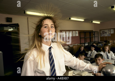 Ein Teenager-Mädchen-Schüler hat eine haarsträubende Erfahrung während einer Schulklasse Wissenschaft durch berühren einen Van Der Graff Generator. Stockfoto